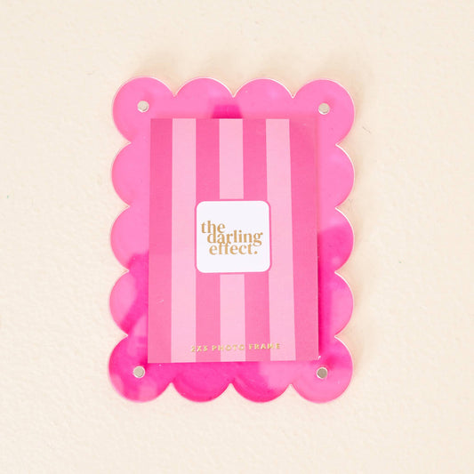 Mini acrylic frame magnet in hot pink with scallop edges, gold text, and four corner holes. Size: mini.