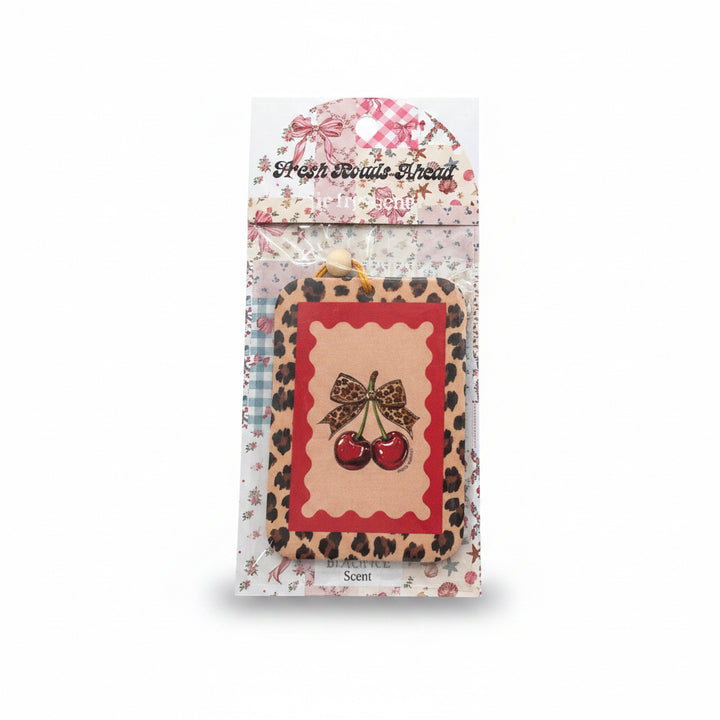 SIMPLY SOUTHERN FRESH ROADS AHEAD air freshener with leopard print border, red frame, gold bow, and two cherries. Sizes: S/M/L.