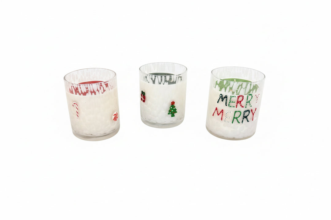 Set of three holiday soy candles in glass holders with festive designs: candy cane, Christmas tree, and “MERRY MERRY” in green and red. Available sizes: 8 oz, 16 oz.