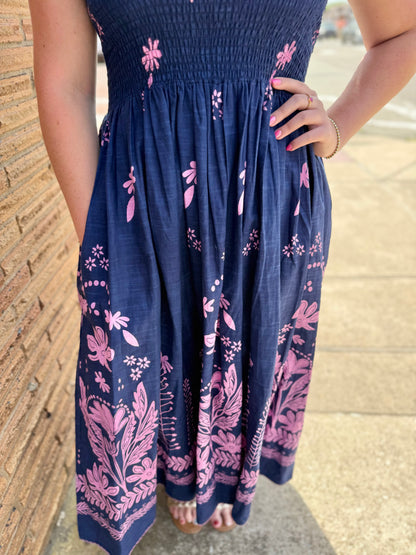 Navy Smocked Border Dress with pink floral patterns. Available in sizes XS-XL.