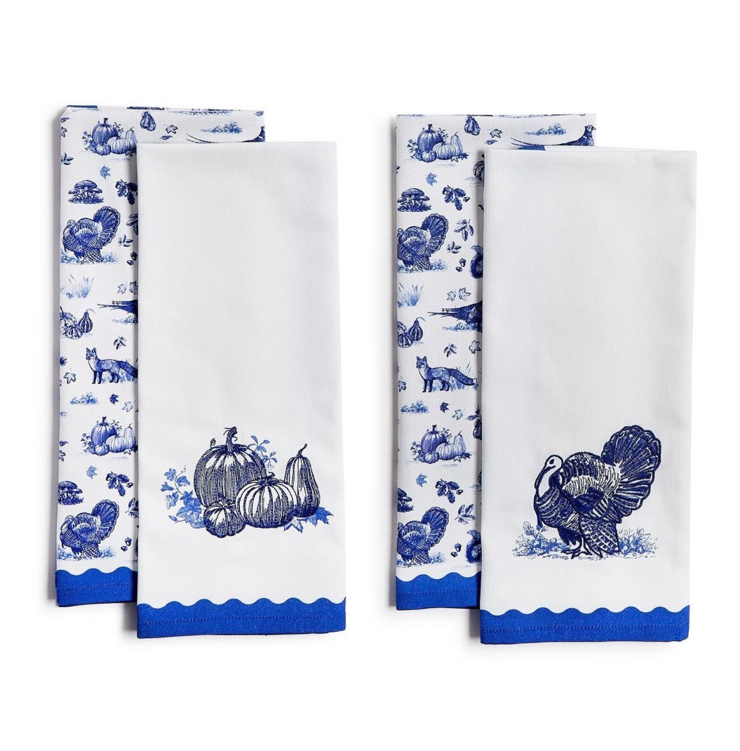 Set of four white kitchen towels with blue prints; two feature autumn motifs (pumpkins, turkeys), two have blue scalloped edges with embroidered pumpkin or turkey designs. Sizes available: 18″ x 28″.