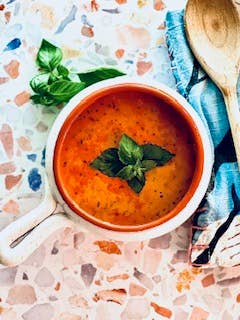 Tomato Basil Soup Mix in a bowl, topped with fresh basil. Available sizes: 8oz, 16oz. Rich French Bistro flavor.
