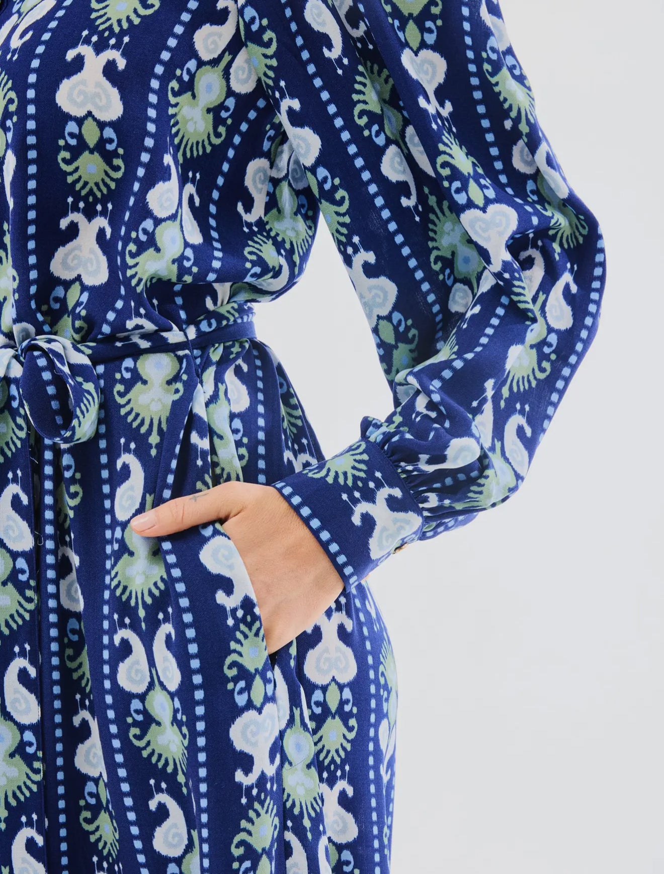 Ava Ikat Stripe Dress: blue midi with white/green pattern, belted waist, long puff sleeves. Sizes XS–XL available.