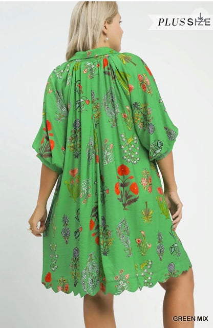 Floral Encyclopedia Print Mini Dress—plus-size, green with colorful floral prints, scalloped hem. Sizes 1X-4X available.