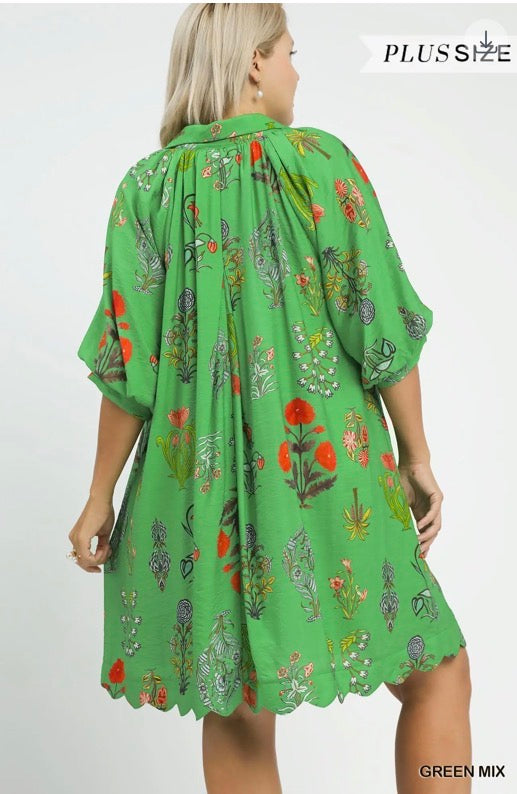 Floral Encyclopedia Print Mini Dress—plus-size, green with colorful floral prints, scalloped hem. Sizes 1X-4X available.