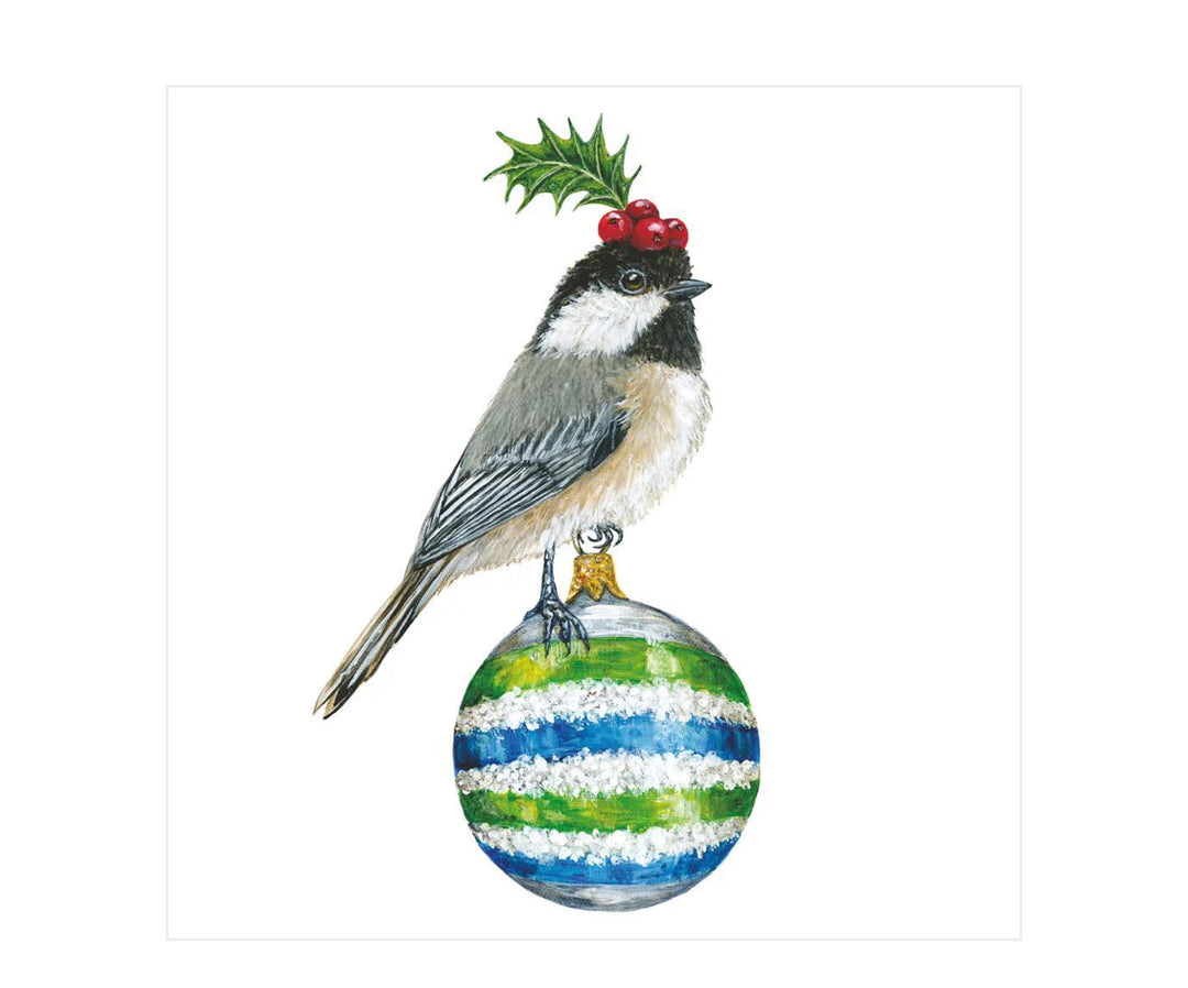 Holiday napkin featuring a chickadee with a sprig of holly on its head, perched on a blue, green, and white striped Christmas ornament.