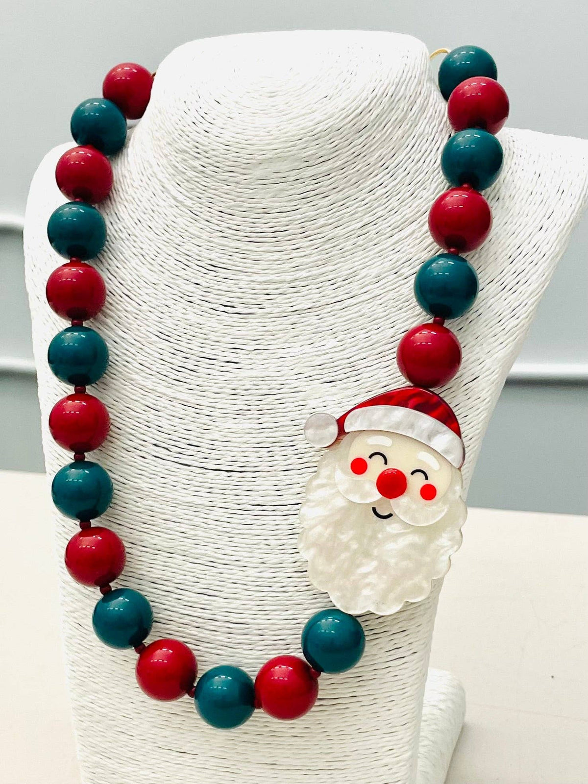 The HOLIDAY - Beaded Santa Necklace (red/green) BNK1213 features alternating red and green beads with a Santa pendant. Available sizes: S, M, L.