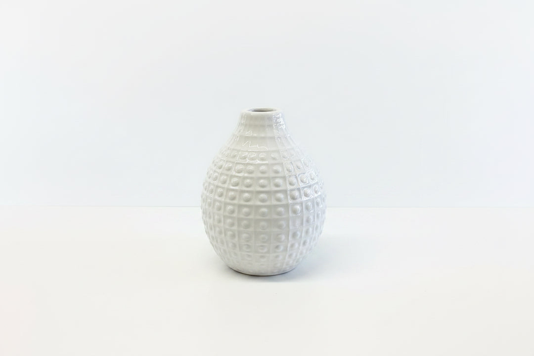 Small white ceramic vase with a narrow opening and raised grid dots. Available in multiple sizes.