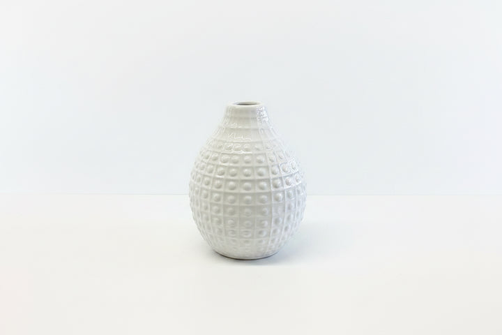 Small white ceramic vase with a narrow opening and raised grid dots. Available in multiple sizes.