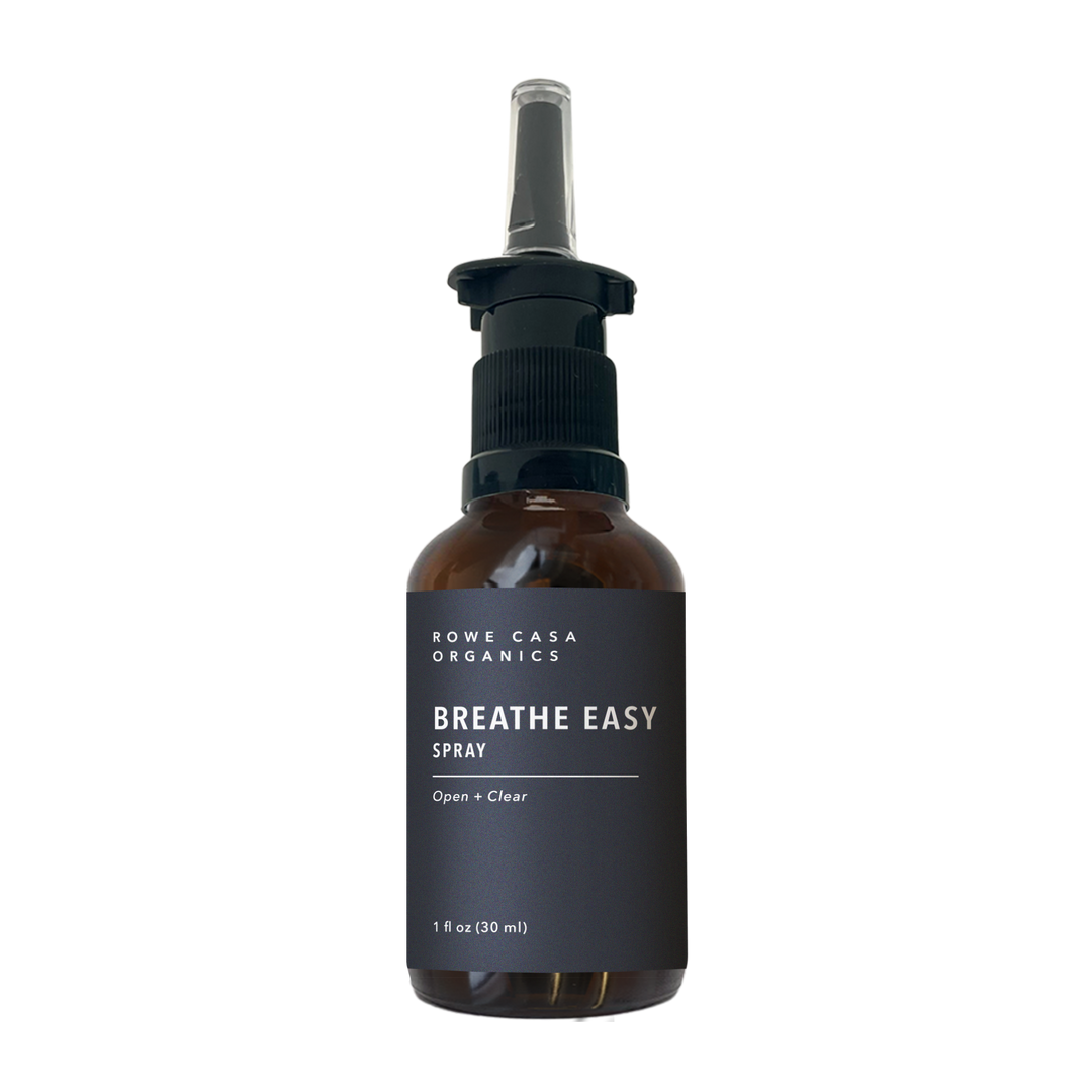 1 oz brown glass bottle labeled “Breathe Easy Spray” by Rowe Casa Organics with a black pump top and clear nozzle attachment.