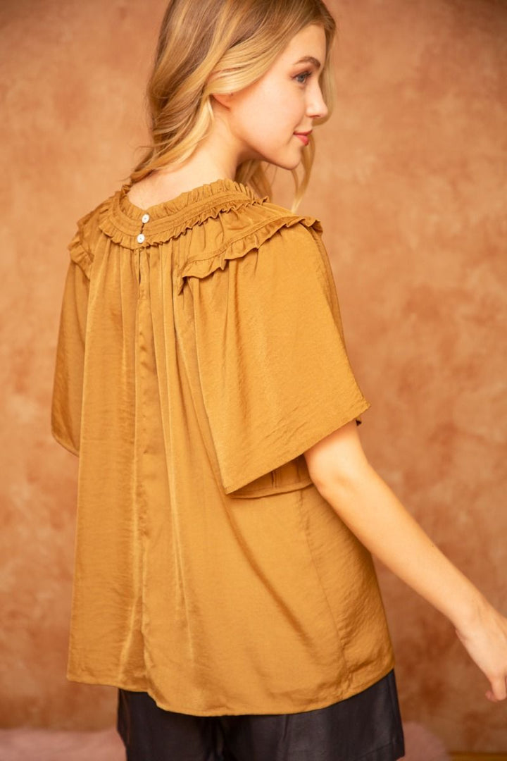 Ruffle Round Neck Golden Top with short wide sleeves, ruffle details, and back buttons. Available in sizes XS–XL.
