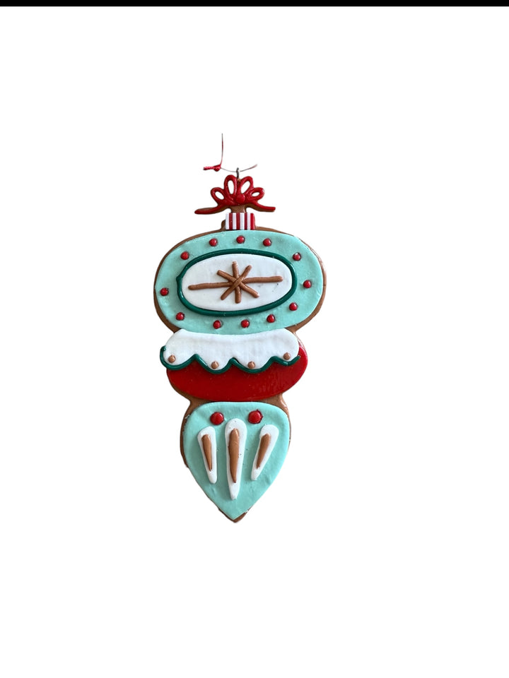 Retro starburst clay dough ornament in teal, red, and white with a red bow.
