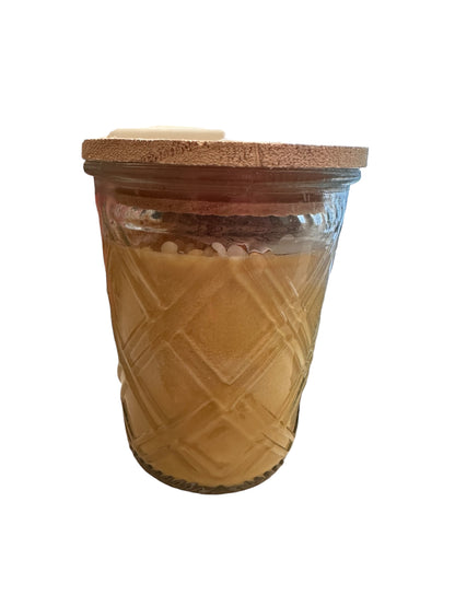 Clear, diamond-patterned glass jar with a smooth wooden lid. Contains Pumpkin Caramel Drizzle Candle made from soybean wax. Sizes available: 8 oz, 16 oz.
