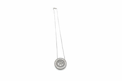Silver circular pendant with bold "R," framed by sparkling stones. Available in 16", 18", and 20" chain lengths.