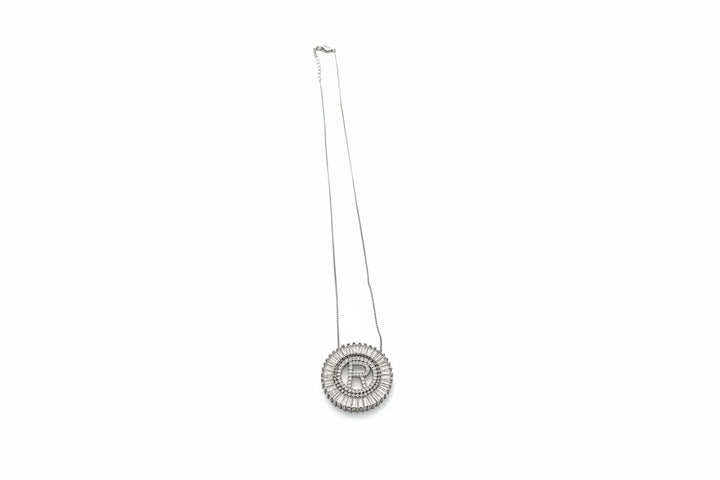 Silver circular pendant with bold "R," framed by sparkling stones. Available in 16", 18", and 20" chain lengths.