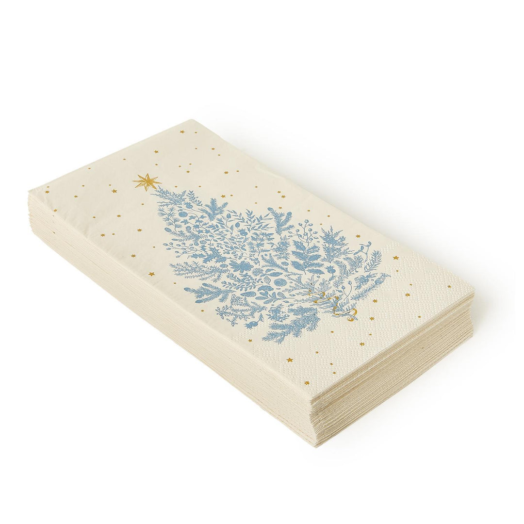 Stack of Gilded Cottage paper dinner napkins and guest towels featuring a blue Christmas tree and gold stars.