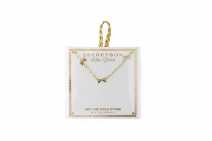 Gold Dipped Dainty Bow Station Necklace with small charms on a card, available in one size. Gold string loop at the top.