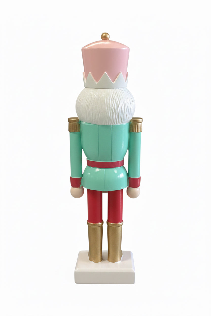 Back view of a mint green, pink, red, and gold Holiday Nutcracker on a white base.