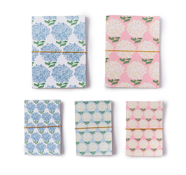 Set of five Hydrangea Soft Cover Notebooks in blue and pink, each with yellow elastic and unlined recycled cotton pages. Sizes: A5, A6.