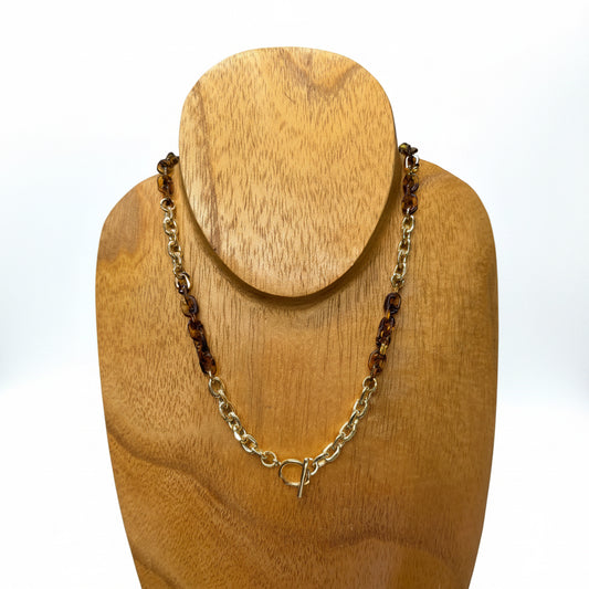 The Eva Tortoise Toggle Necklace features gold metal links and tortoiseshell accents. Available in 16-inch and 18-inch lengths.