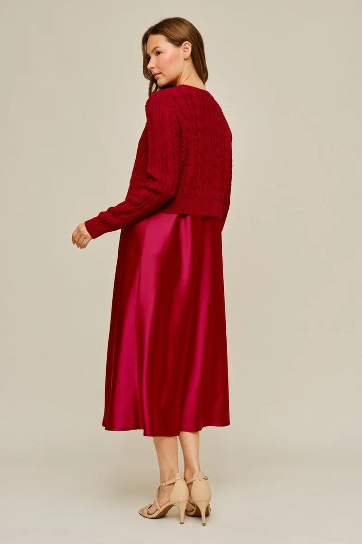 Red cable-knit sweater and red satin midi dress. Sizes available.