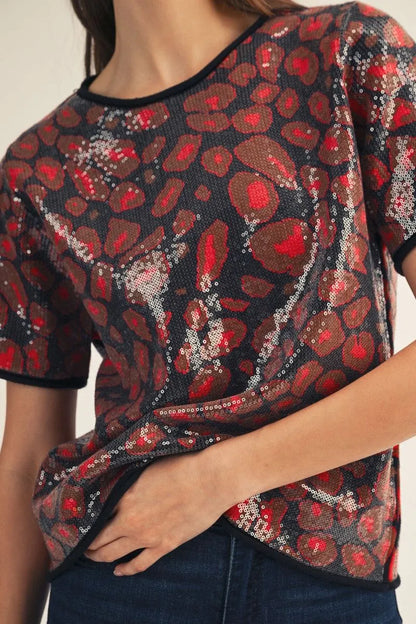 Red Sequin Covered Leopard Sweater Top—short sleeves, striking red and black animal print. Available in sizes XS–XL.