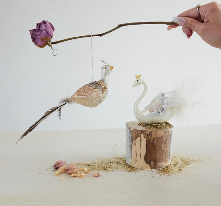 Mercury glass swan ornament with gold details and beaded feathers.