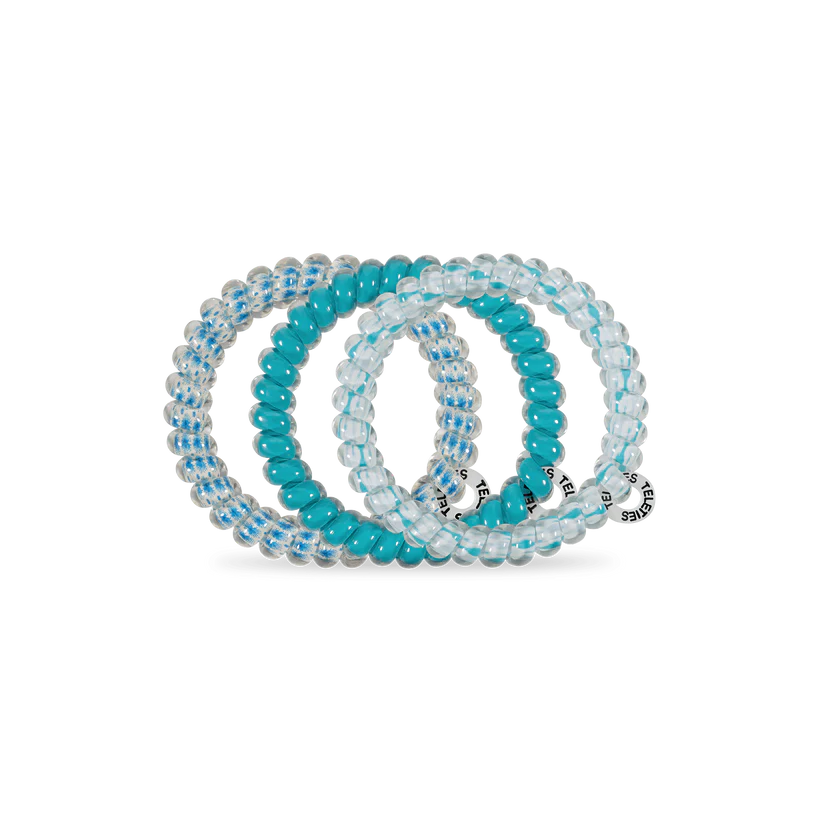 Three TELETIES Hair Ties: two clear with blue stripes, one solid turquoise, each with a small charm. Available in various sizes.