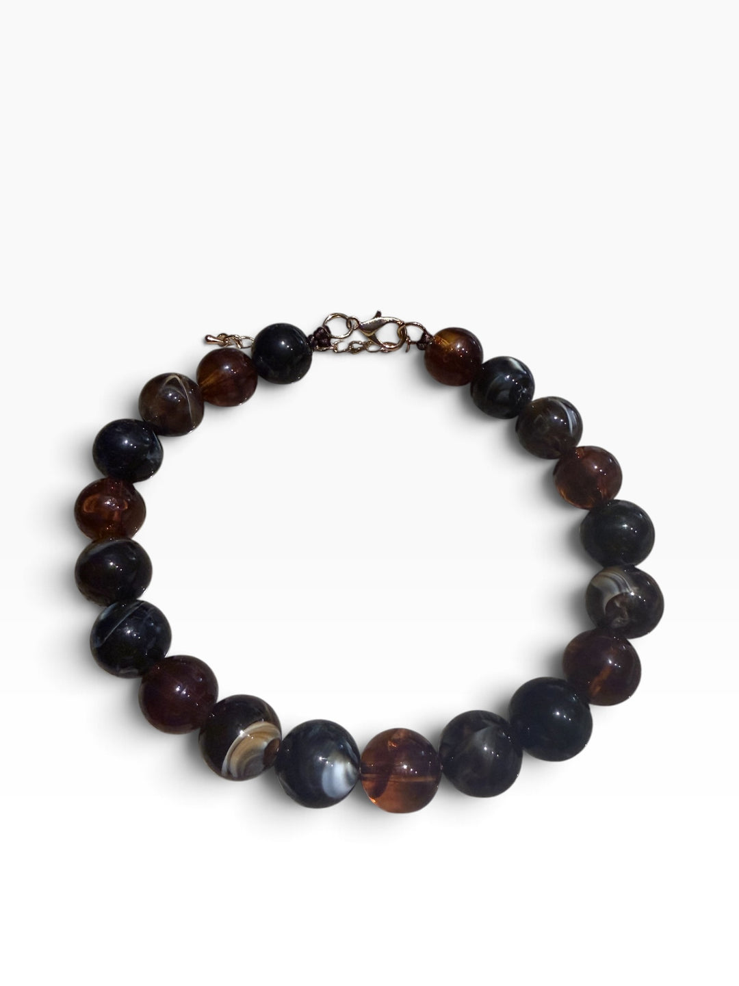 Marbled beaded necklace with brown, black, and amber beads and a metal clasp. Available in various sizes.