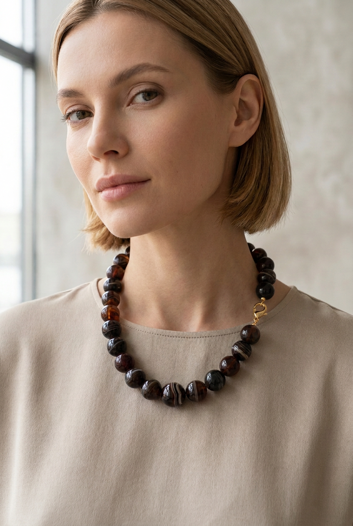 Dark marbled beaded necklace with gold-tone clasp.