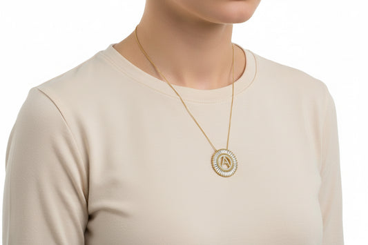 Gold circle pendant necklace with "A" initial, baguette crystals; available in 16", 18", and 20" chain sizes.