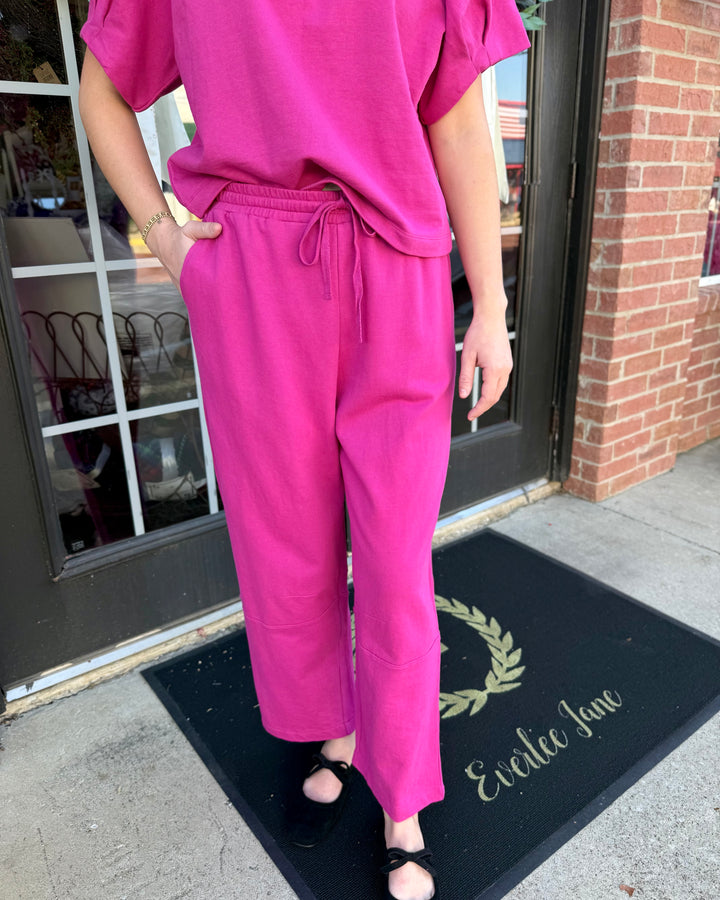 Fuchsia barrel-leg knit pants with elastic drawstring waistband and side pockets. Available in all sizes.