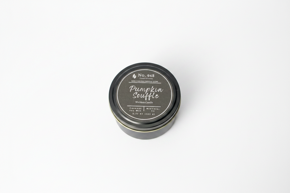 A small, round black tin labeled "Wickless Candle 5.75 oz" in coconut soy wax with "Pumpkin Souffle" and product details on the lid; available in 5.75 oz size.