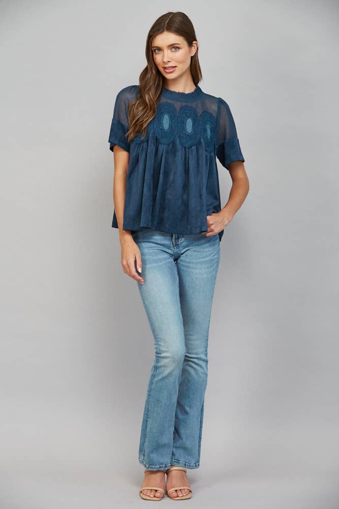 Teal blue short-sleeved faux suede top with sheer mesh upper panel and lace applique detail.