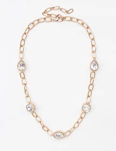 Gold chain necklace with oversized links and five clear gemstone pendants in various shapes. Sizes available: Short.