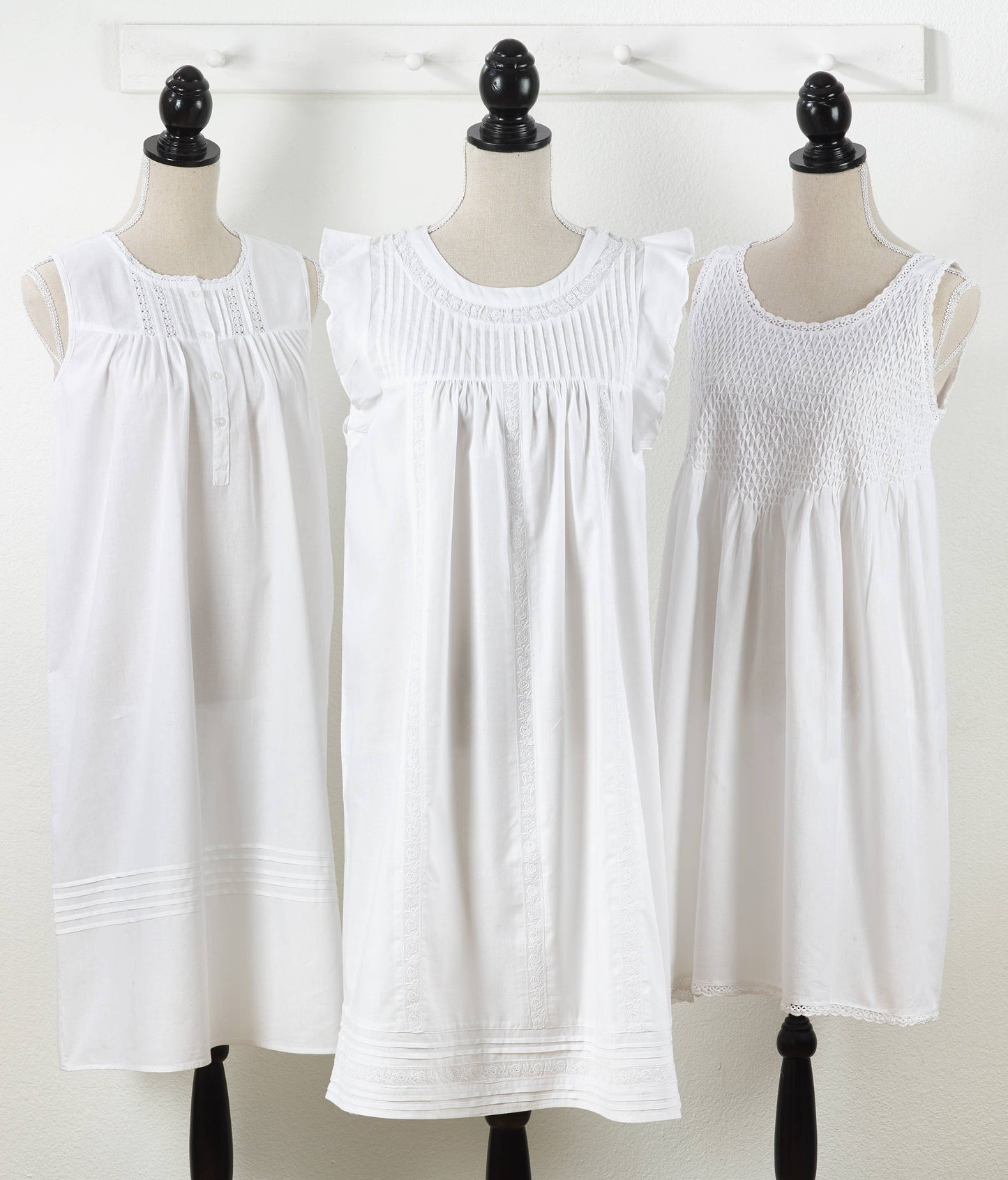 White embroidered nightgowns with pintucks, ruffles, or smocking; above-knee length. Sizes: S, M, L.