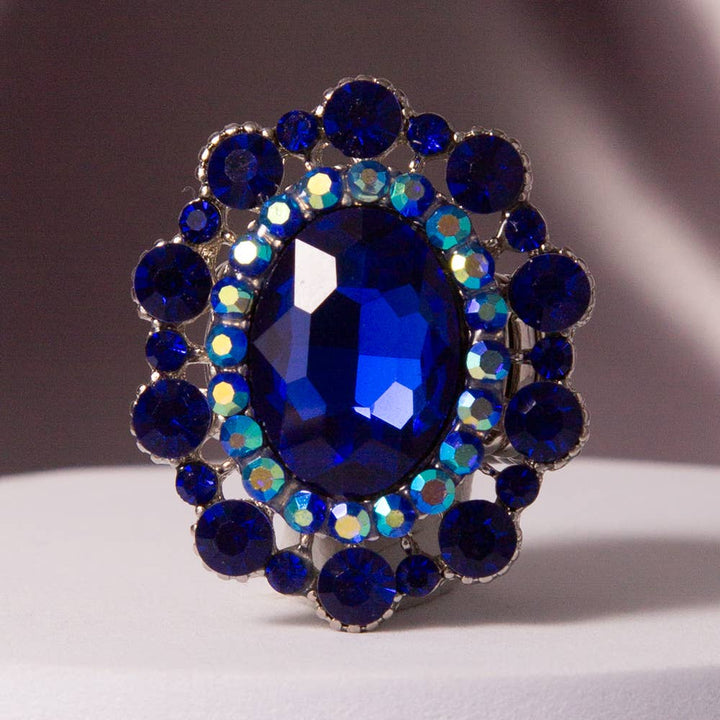 Oval Crystal Sunburst Double Halo Stretch Ring with blue gemstone, blue and iridescent crystals. Available in S/M, M/L.