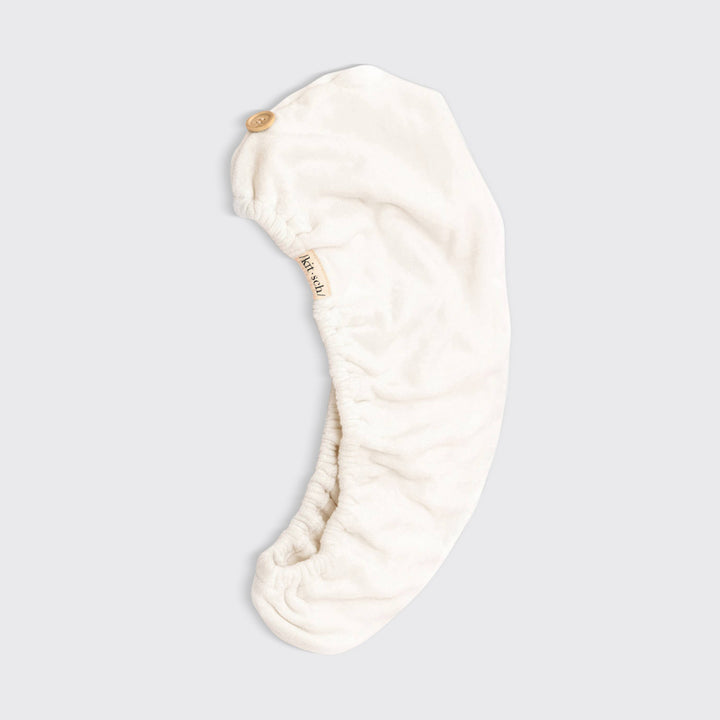 Cream-colored microfiber hair towel wrap with button closure; eco-friendly. Available in S/M and L/XL. Quick-drying care.