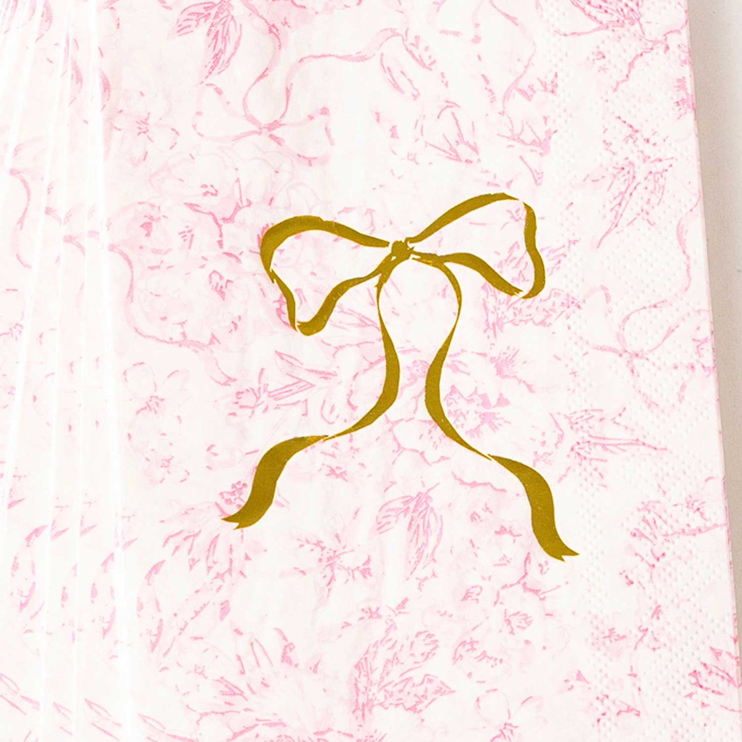 Pink Bow Toile Paper Guest Towel Packs with a gold bow illustration. Available sizes: standard and large.