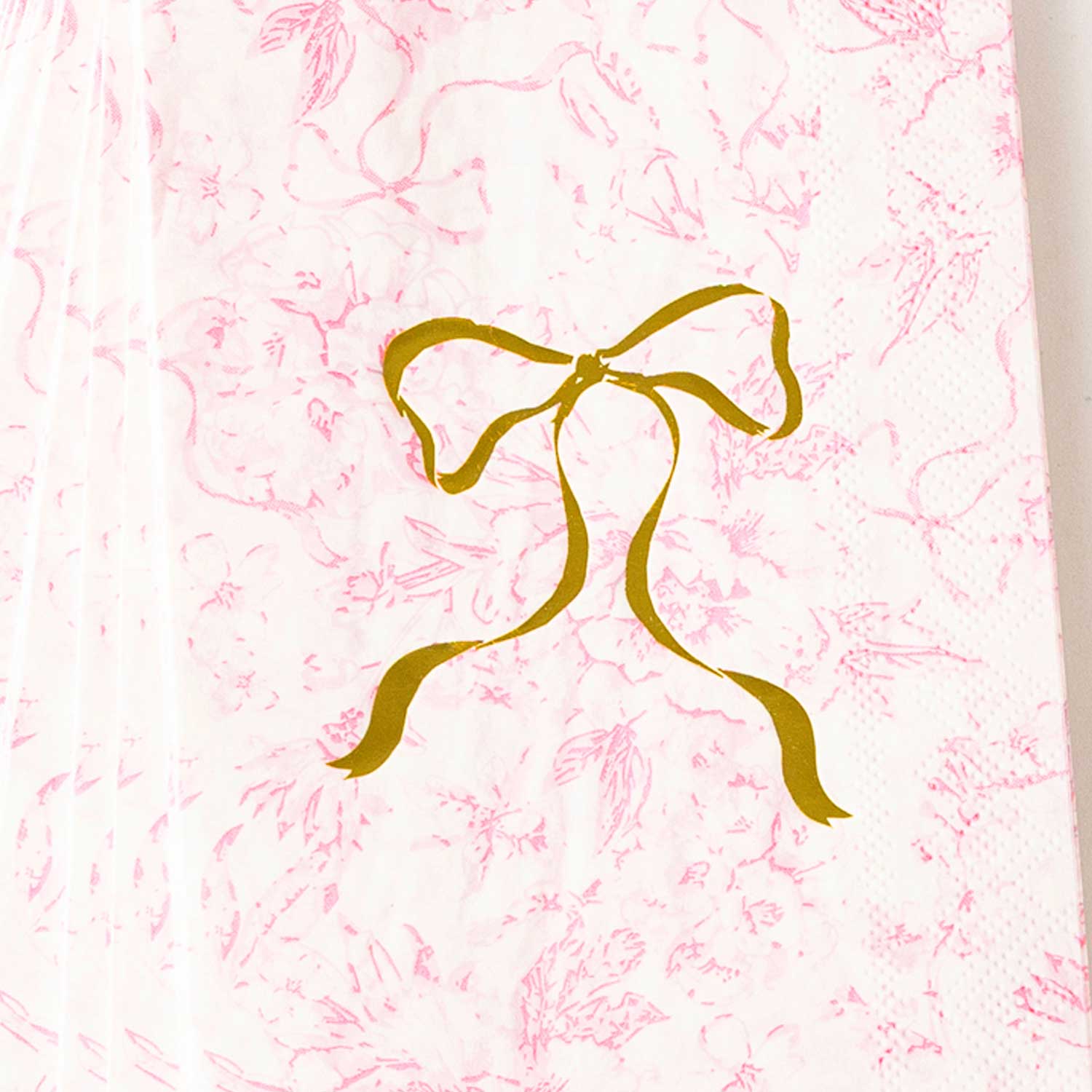 Pink Bow Toile Paper Guest Towel Packs with a gold bow illustration. Available sizes: standard and large.