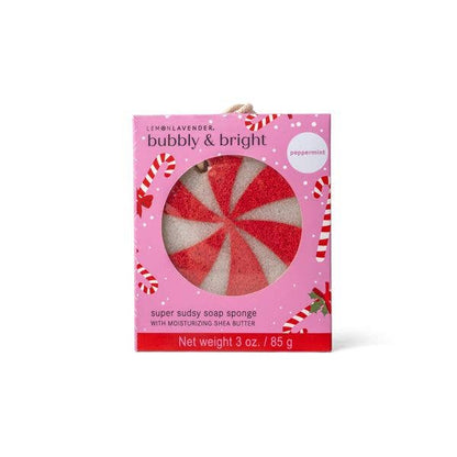 The Lemon Lavender Bubbly and Bright Super Sudsy Soap Sponge is packaged in a pink box with candy cane designs and includes a round red-and-white peppermint swirl exfoliating sponge labeled “bubbly & bright” and “super sudsy soap sponge with moisturizing shea butter.” Sizes available not specified.