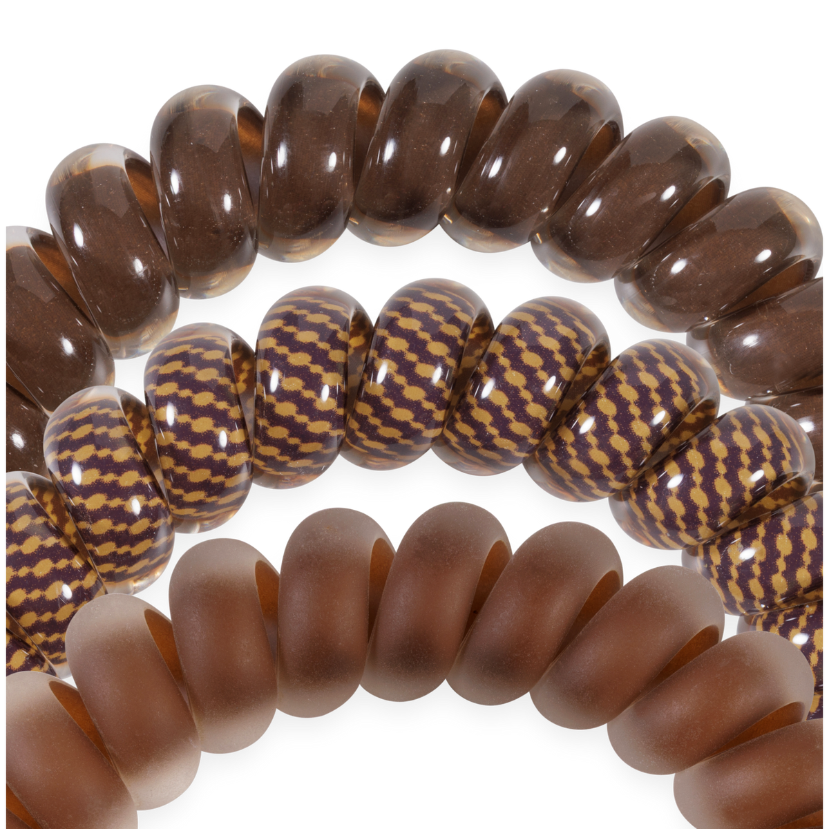 Set of three large hair ties: translucent brown, brown with a yellow zigzag, and matte brown; thick, smooth coils for no-crease hold. Available in large size.