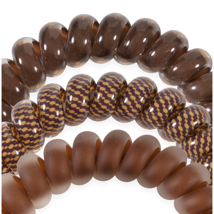 Set of three large hair ties: translucent brown, brown with a yellow zigzag, and matte brown; thick, smooth coils for no-crease hold. Available in large size.