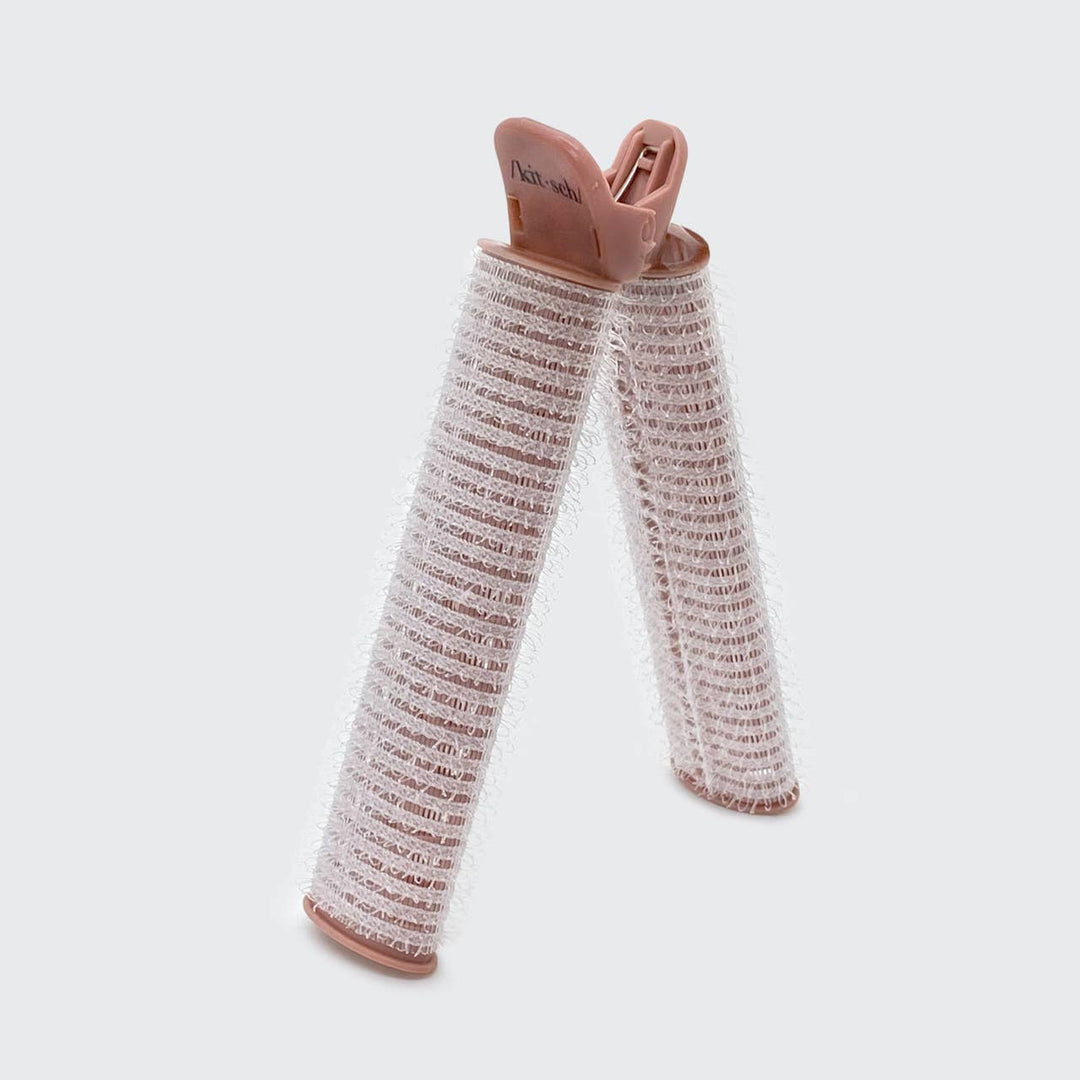 Two large pink Volumizing Roller Clips in an inverted “V” shape. Available in large size; for creating curls and adding volume.