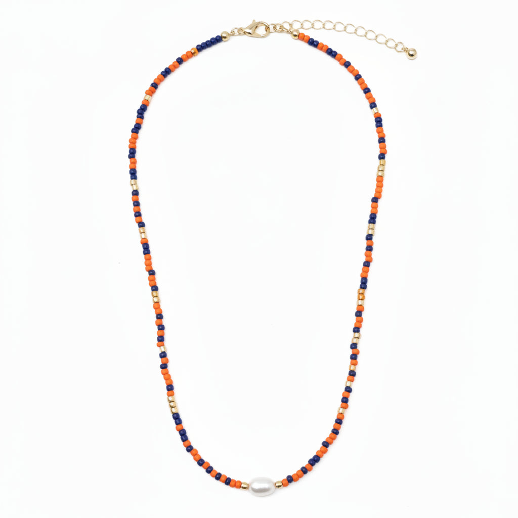 Coach Orange Blue Beaded Necklace with alternating orange, blue, and gold seed beads, a central white oval bead, gold clasp, and adjustable chain. Available in choker size.