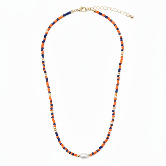 Coach Orange Blue Beaded Necklace with alternating orange, blue, and gold seed beads, a central white oval bead, gold clasp, and adjustable chain. Available in choker size.