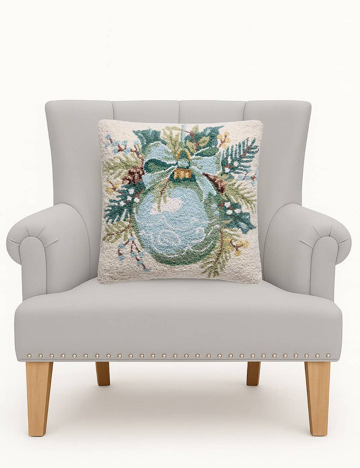 Ornament Square Hook Pillow: a wool Christmas throw pillow with an embroidered holiday wreath, greenery, bow, and pinecones. Available in 18″x18″.
