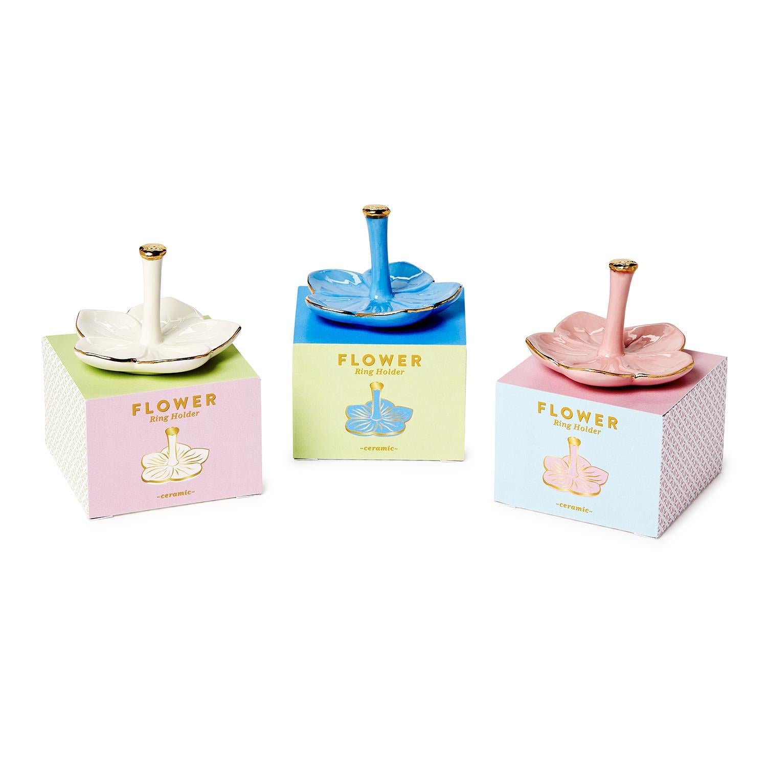 The Flower Haven Ceramic Ring Holders come in white, blue, and pink with gold-tipped stems. Sizes: small, medium, large.