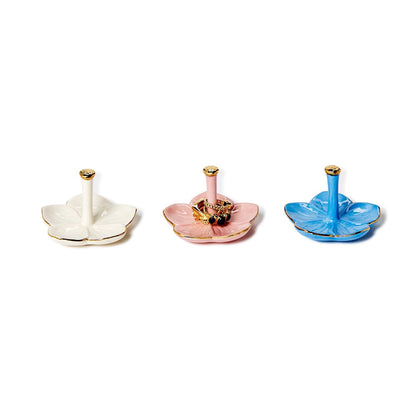Flower Haven Ceramic Ring Holders in white, pink, or blue with gold accents; flower-shaped; central rod; sizes S, M, L.