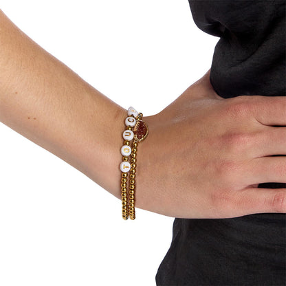 Game Day Stretch Bracelet Set featuring gold beads and white letter beads spelling “care.” Available in small, medium, and large sizes.